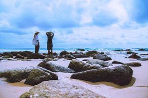 Asian lover woman and man travel nature. Travel relax. On the rocks at the sea. In the summer. Thailand photo