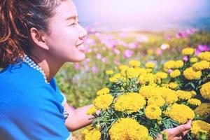Asian women travel sleep relax. women hill tribe flower sitting in the field of flowers Tagetes erecta. Thailand