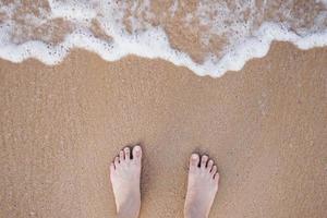 concepto de vacaciones de verano descalzo sobre la arena en la playa con copyspace. foto