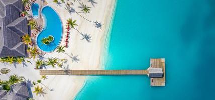 Perfect aerial landscape, luxury tropical resort or hotel with water villas and beautiful beach scenery. Amazing bird eyes view in Maldives, landscape seascape aerial view over a Maldives photo