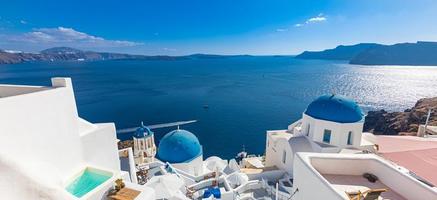 Amazing panoramic landscape, luxury travel vacation. Oia town on Santorini island, Greece. Traditional and famous houses and churches with blue domes over the Caldera, Aegean sea