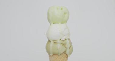 Front view, Melting of three ice cream balls on the cone. Different flavors of ice cream flow from the cones.