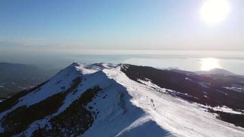 voando sobre os picos das montanhas e o lago no inverno video