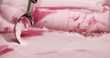 close-up, aardbeienijs geschept met een lepel. roze van aardbei en yoghurt. video