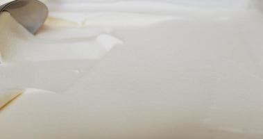 close up, sorvete de baunilha com uma colher. depois de colher o sorvete vai rolar em uma bola redonda. video