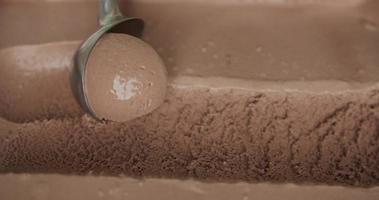slomotion, Schokoladeneiskugeln, die von einem Löffel aufgeschaufelt werden. Textur der Schokolade die Einstellung des Eises. video