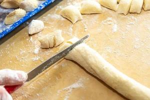 Manos de anciana preparando ñoquis de pasta fresca italiana. concepto de cocina tradicional italiana foto