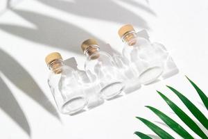 Three glass bottles with cork stoppers for perfumes with exotic plants. Mockup. photo