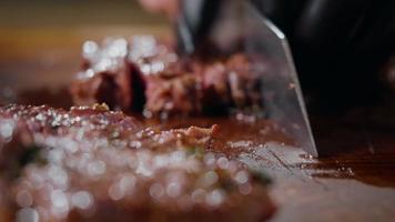 El chef cortando una carne de res medianamente cocida se ve muy sabroso. video