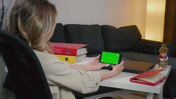 achteraanzicht van zakenvrouw aan de telefoon met groen scherm voor kopieerruimte. video