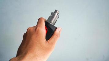 A man's hand is holding a vape or e-cigarette photo