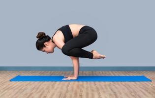 Young asian woman practicing yoga pose at yoga healthy sport gym, yoga and meditation have good benefits for health. Photo concept for Yoga Sport and Healthy lifestyle.