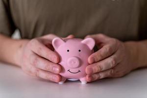 The businessman's hands hold a pink piggy bank. photo