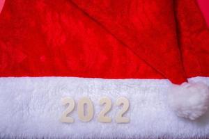 Santa's hat and the numbers of 2022 on a red background. photo