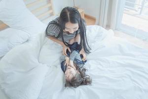 Happy loving family, Pretty young mother playing with her daughter in kid's room.Photo design for family, kids and happy people concept photo