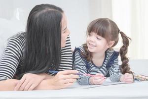 Happy loving family mother and her daughter child girl play in children room. Funny mom and lovely child having fun together.Photo design for family, children and happy people concept photo