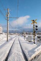 Railway track for local train with white snow fall in Japan photo