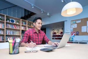 emprendedor de negocios asiáticos ganancias de ingresos récord para computadoras inteligentes en la oficina en casa. conceptual para emprendedores de pequeñas empresas y autónomos.
