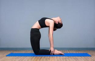 Young asian woman practicing yoga pose at yoga healthy sport gym, yoga and meditation have good benefits for health. Photo concept for Yoga Sport and Healthy lifestyle.