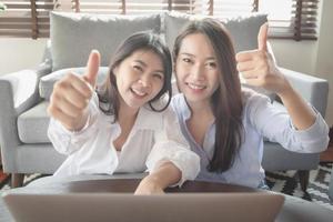 Two young woman use laptop computer to shopping online via internet during stay safe at home photo