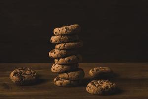 a tower of  chocolate chip cookies on a wooden background photo