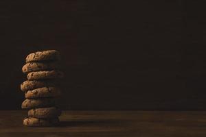 a tower of  chocolate chip cookies on a wooden background photo