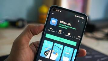 Pekanbaru, Indonesia 2020 - A hand holding a mobile phone opens the BRImo BRI application. Display of BRImo BRI application on android mobile. photo