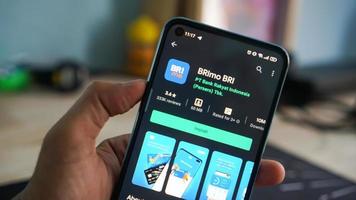 pekanbaru, indonesia 2020: una mano que sostiene un teléfono móvil abre la aplicación brimo bri. visualización de la aplicación brimo bri en dispositivos móviles Android. foto