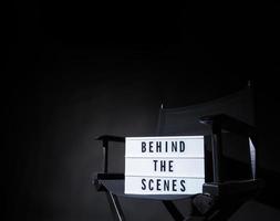 silla de director con caja de luz de banner detrás de escena. foto