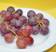 Grandes uvas rojas en un plato foto