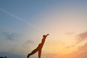 silhouette of a man doing yoga exercises photo