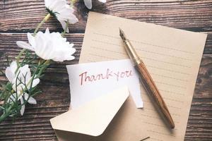 thank you message and envelope on wooden table photo