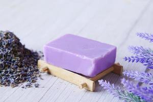 Homemade natural soap bar and lavender flower on purple background photo