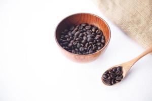 coffee beans in a wooden bowl on a white table photo