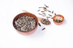 Sunflower seeds in a wooden bowl on a white table photo