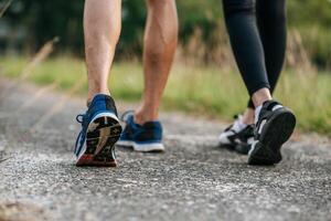 corredor de pies de mujer y hombre corriendo en primer plano de la carretera en el zapato. concepto de estilo de vida saludable deportivo. foto