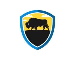 Escudo de protección con bisontes y puesta de sol detrás. vector