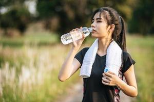 las mujeres se ponen de pie para beber agua después del ejercicio