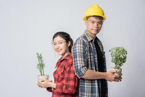 Men and women standing and holding plant pots in the house photo