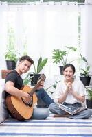 hombres sentados a la guitarra y mujeres sosteniendo libros y cantando. foto