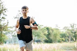 Men exercise by running on the streets with trees and flowers. photo