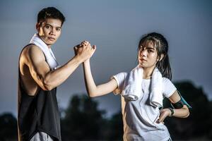 Women and men stand holding hands to exercise. photo