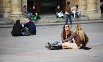 Bologna, Italy, 2019 - People sitting on ground of Piazza Maggiore, Bologna, Italy photo