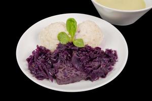 Tempeh with red cabbage and sorghum on a black photo