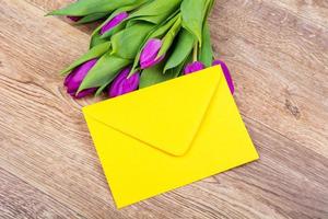 Yellow envelope with tulips on a table photo