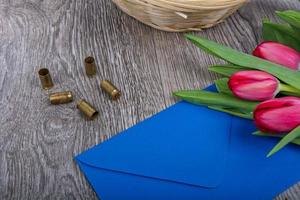 Pink envelope with tulips on a wooden table photo