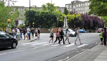London, United Kingdom, 2014 - Tourist walk the pedestrian crossing of Abbey Road, just like The Beatles did in 1969. photo