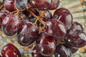 Fresh grapes with water droplets on plate, ready to eat