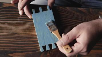 carpintero pinta una pieza de madera