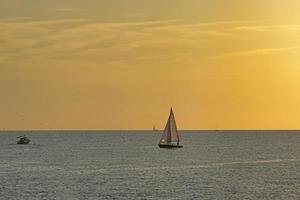 Seascape with boats and sailboats at sunset. photo
